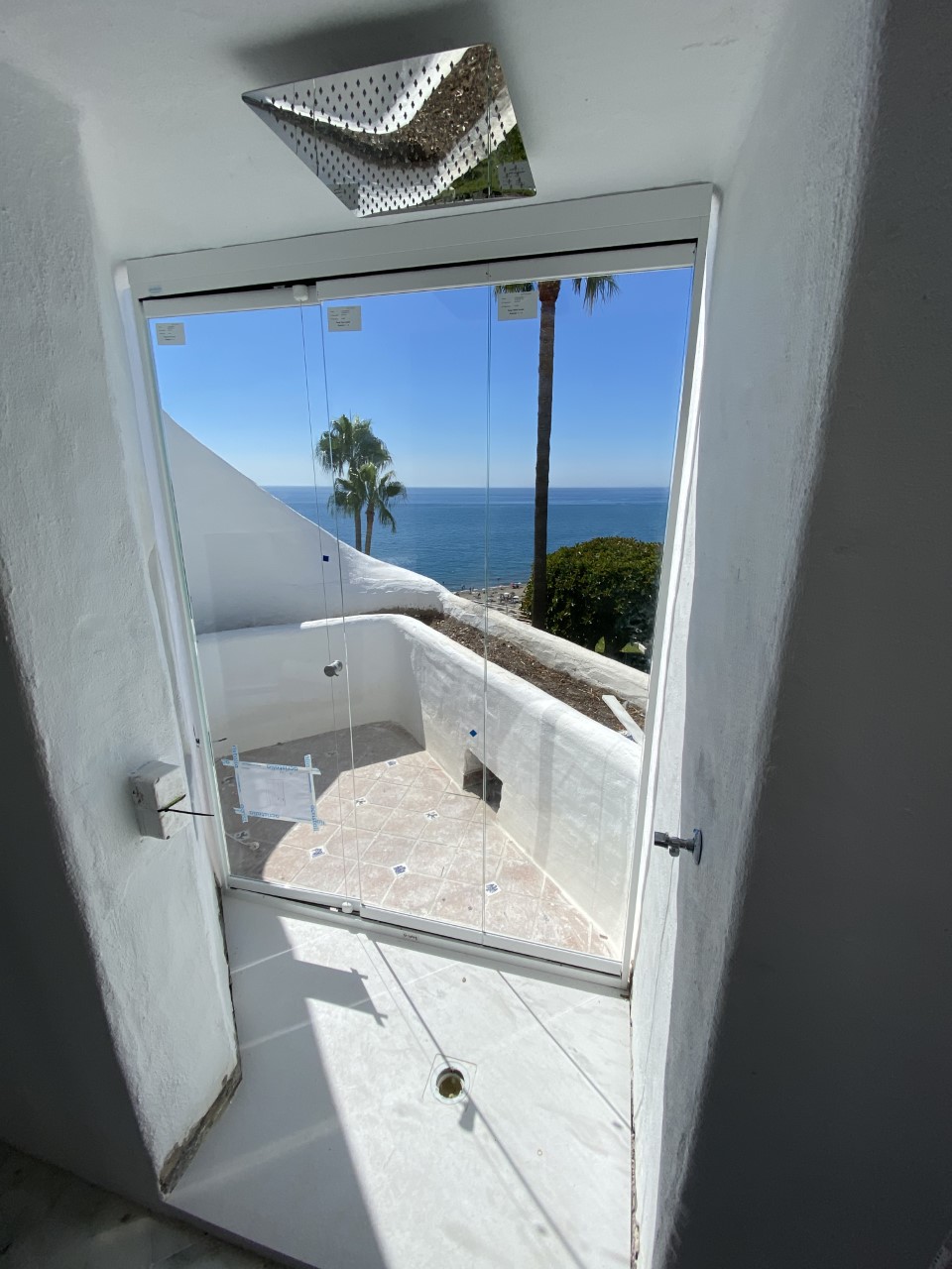 Terraza cerrada con cortina de cristal y vistas al mar